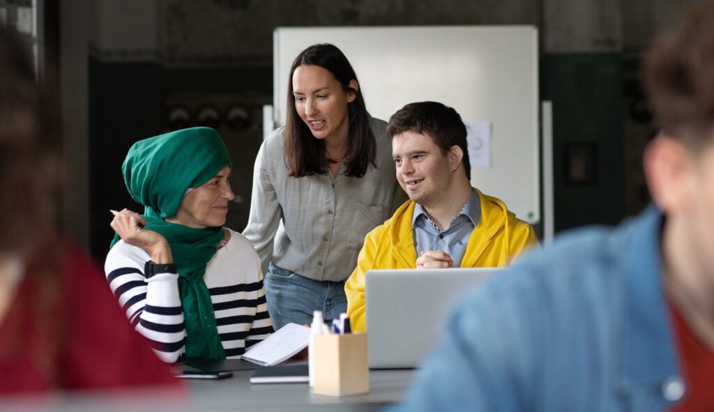A behaviour support practitioner talking warmly with two young people in a community setting