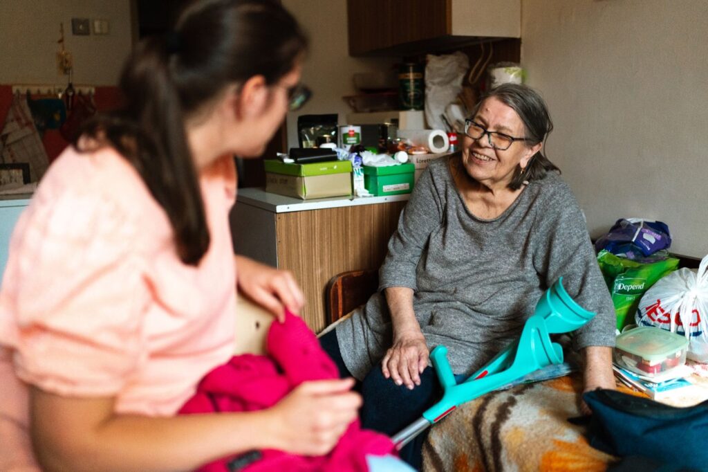 A support worker respectfully assisting an older person at home