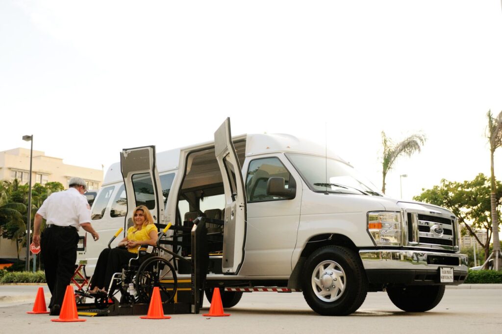 A person boarding an accessible van using a wheelchair ramp