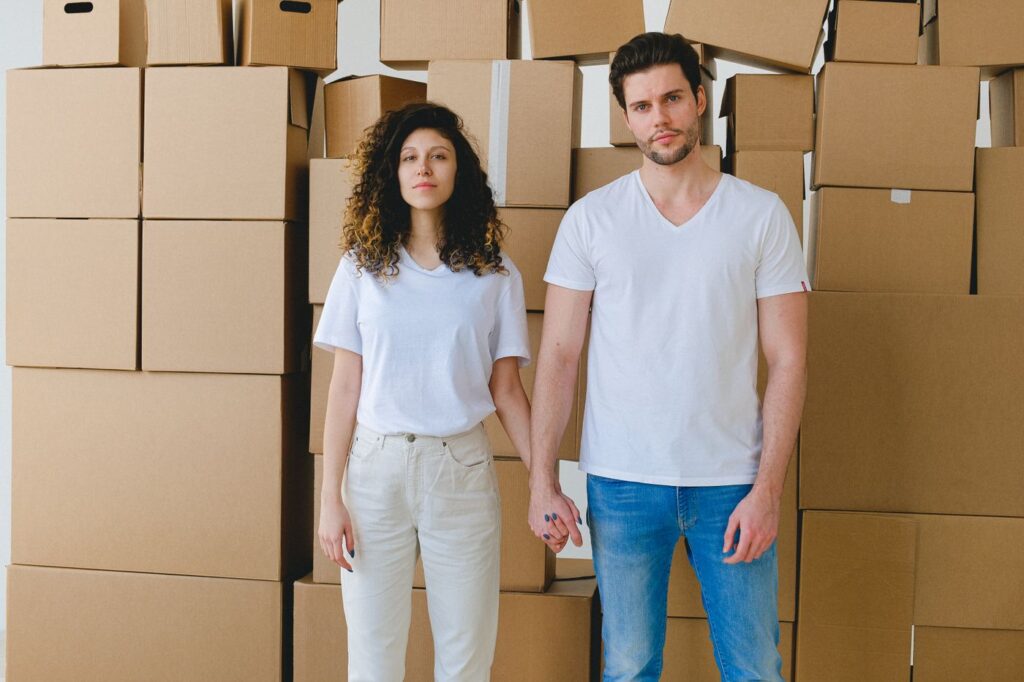 A couple standing together among moving boxes in a new home